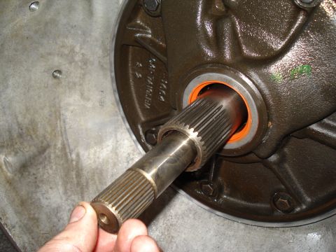 1984 Ford Bronco - Close-up of a transmission component, possibly a pump shaft, being handled.