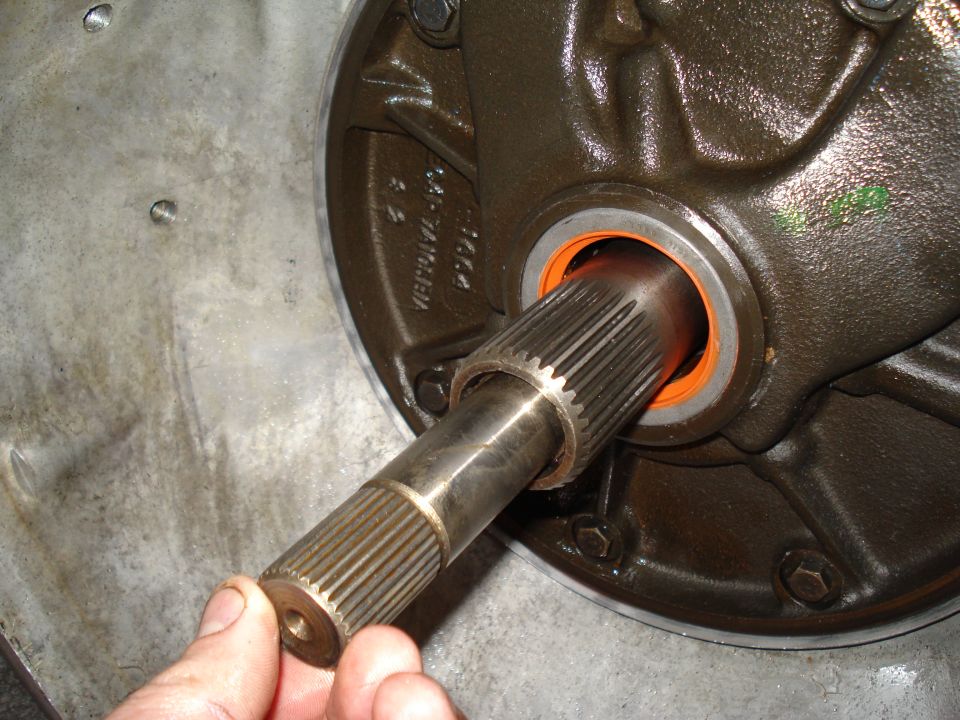 Splined shaft being inserted into a transmission housing with an orange seal