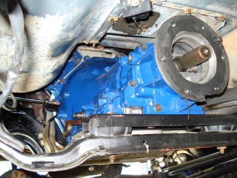 1984 Ford Bronco - Underside view of a freshly painted blue transmission and driveshaft, likely part of a vehicle repair or rebuild.