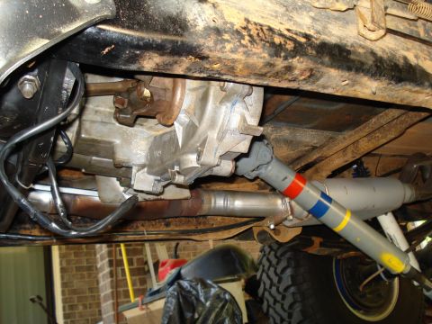 1984 Ford Bronco - Close-up view of the transmission and driveshaft assembly from underneath a vehicle.