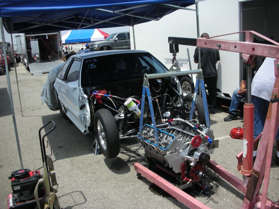 drag car with engine out, being worked on with an engine hoist