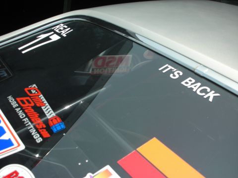 1998 Ford Crown Victoria - Stickers adorn the rear window of a car, including 'REAL 17' and 'IT'S BACK'.