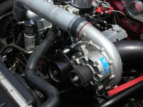 1998 Ford Crown Victoria - Close-up view of a vehicle's engine bay, focusing on a supercharger and associated components.