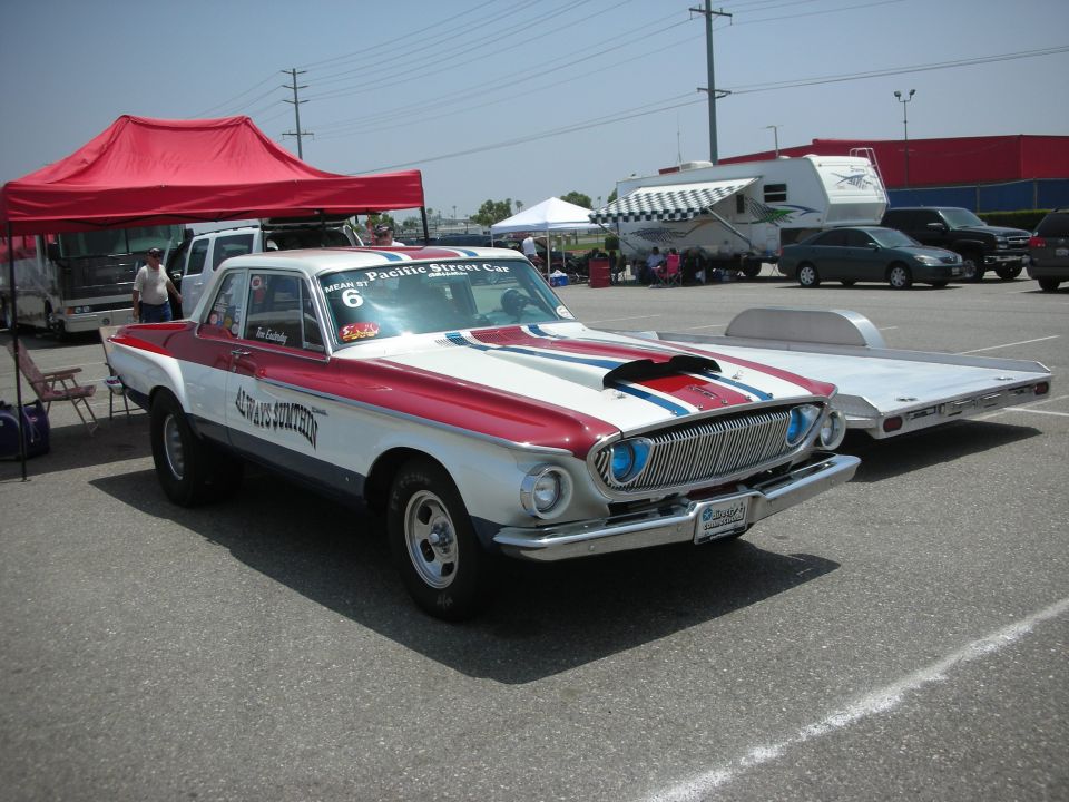 Red and white drag car with racing stripes and hood scoop, front view