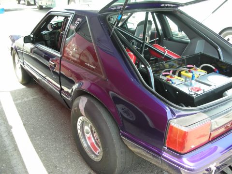 1998 Ford Crown Victoria - A custom purple drag car is shown with its trunk open, revealing a roll cage and fuel system.