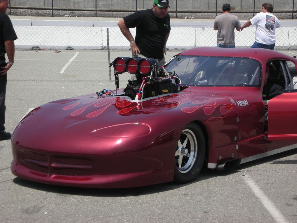 Red drag car with flames, supercharger, and HEMI text on the side