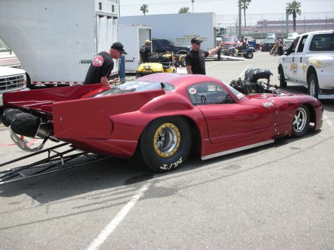 1998 Ford Crown Victoria - A custom red drag car is prepared for a race, with a white truck visible in the background.
