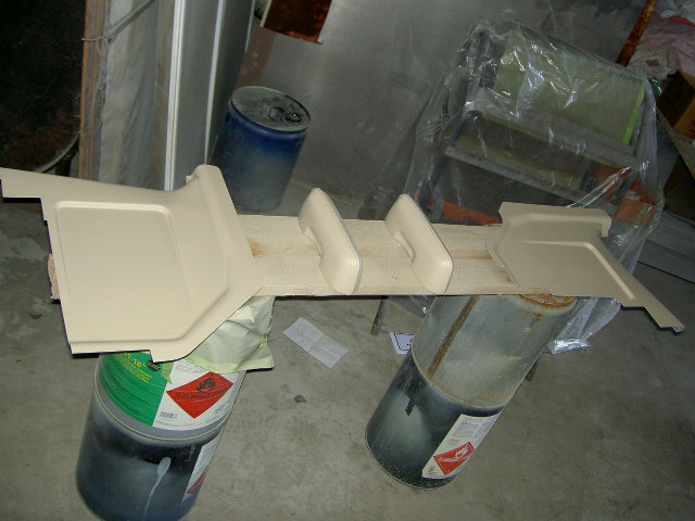 Tan interior trim piece with two grab handles, resting on barrels