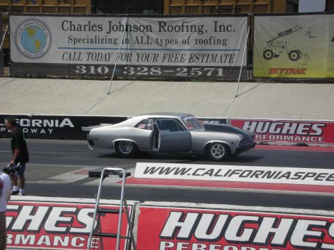 1998 Ford Crown Victoria - A silver drag car with a black hood stripe sits on the track with its driver's door ajar.