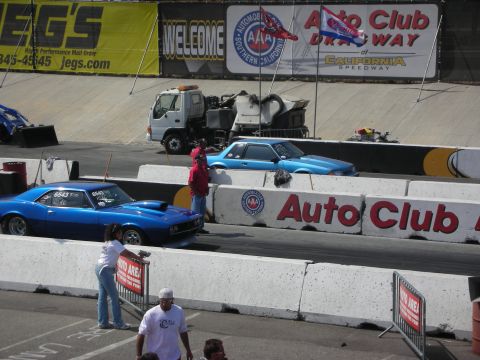 1998 Ford Crown Victoria - Cars prepare for a drag race at Auto Club Speedway, with banners for Jegs and AAA visible in the background.