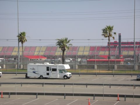 1998 Ford Crown Victoria - A white recreational vehicle is parked in a lot with palm trees and stadium seating visible.
