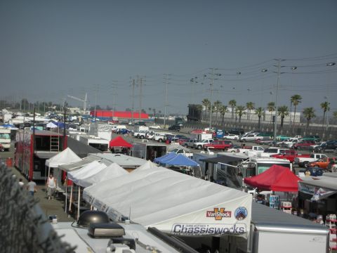 1998 Ford Crown Victoria - A busy parking lot scene with numerous vehicles and vendor tents under a clear sky.