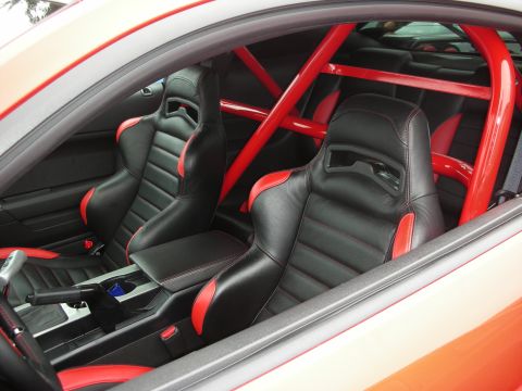 1998 Ford Crown Victoria - The interior of a car is visible, black racing seats with red accents and a red roll cage.