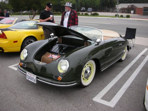 1998 Ford Crown Victoria - A dark green convertible with its hood open is parked next to a yellow sports car at a coffee meet.