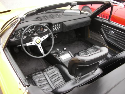 1998 Ford Crown Victoria - Interior view of a yellow convertible sports car with black leather seats and a Ferrari emblem on the steering wheel.