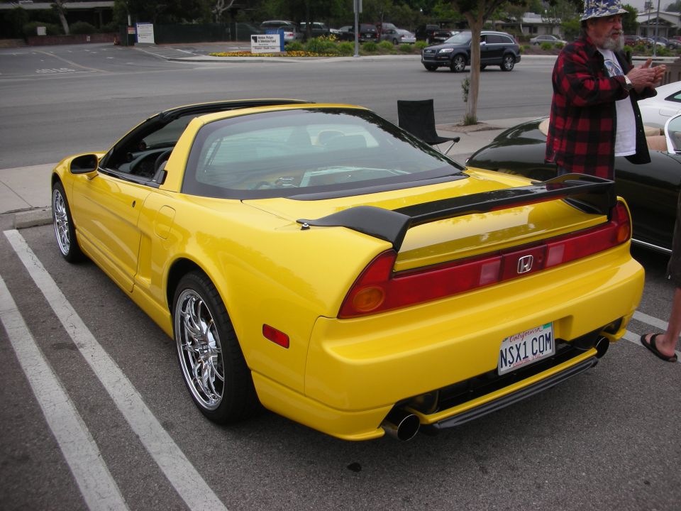 Yellow sports car rear view with black spoiler and custom plate NSX1.COM
