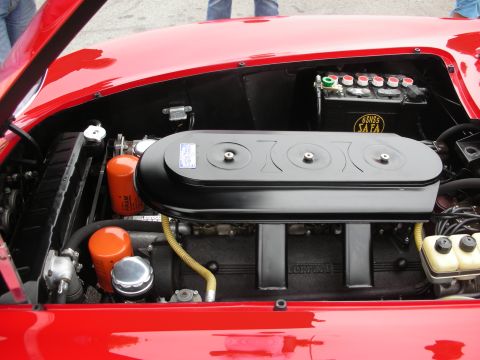 1998 Ford Crown Victoria - The engine bay of a red Ferrari features a prominent black air filter housing and two orange Fram oil filters.