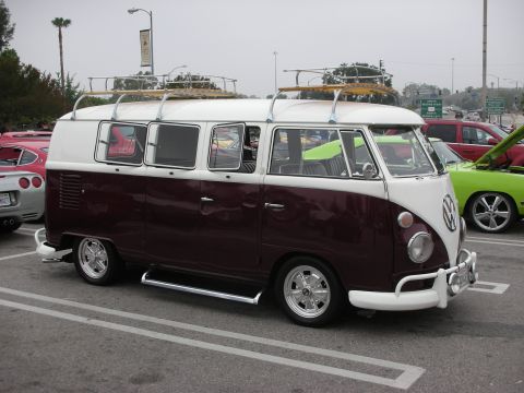 1998 Ford Crown Victoria - A two-tone Volkswagen Type 2 Kombi is parked next to other vehicles at an outdoor gathering.