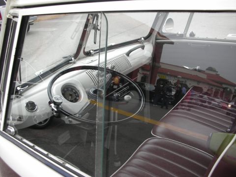 1998 Ford Crown Victoria - The interior of a vintage Volkswagen Bus is visible through the window, with a reflection of a building in the glass.