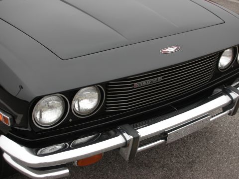1998 Ford Crown Victoria - Front view of a black Jensen Interceptor III, its distinctive chrome grille and dual headlights.