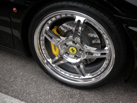 1998 Ford Crown Victoria - Close-up of a chrome wheel a yellow brake caliper with 'Ferrari' text and the iconic Prancing Horse emblem.
