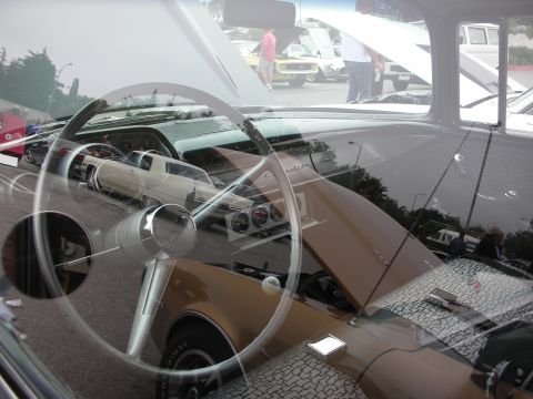 1998 Ford Crown Victoria - A view from inside a classic car, showing the steering wheel and dashboard, with other vehicles visible through the windshield.