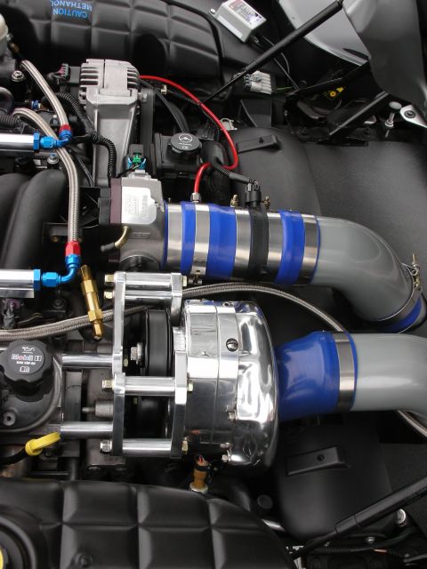 1998 Ford Crown Victoria - Close-up of a modified engine bay, highlighting a supercharger and custom intake system.