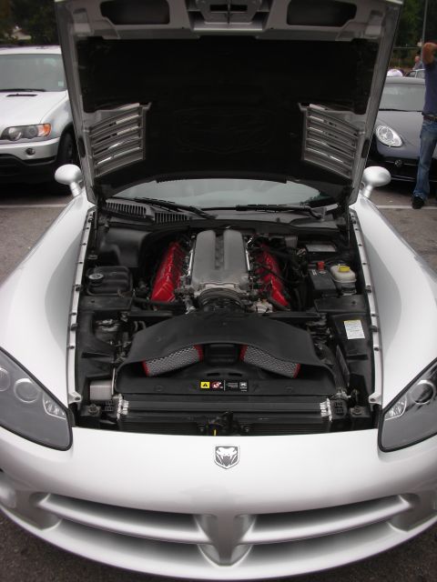1998 Ford Crown Victoria - Silver Dodge Viper's V10 engine bay is exposed, with other vehicles parked nearby.