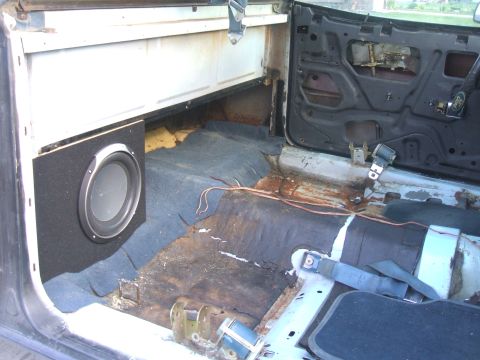 1974 Ford Ranchero - The interior of this vehicle shows significant wear and tear, with a subwoofer installed and the door panel removed.