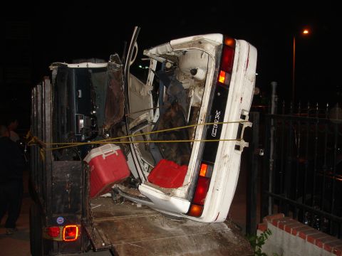 1993 Ford Taurus - A severely damaged car, identified by a "CRX" badge, is secured to a trailer at night.