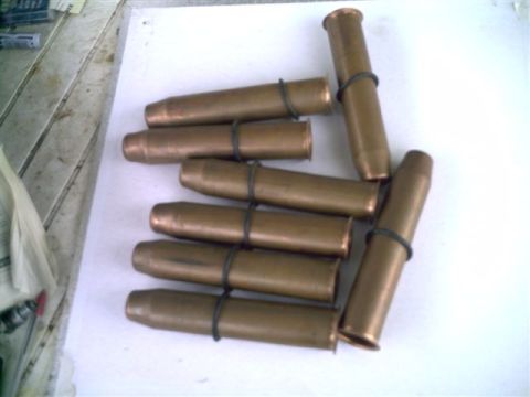 1964 Ford 427 - A collection of ammunition cartridges is laid out on a white surface.