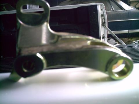 1964 Ford 427 - A metal bracket part is shown in detail, with a vehicle in the background.
