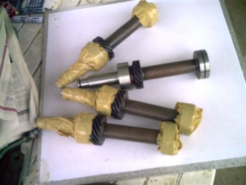 1964 Ford 427 - Four camshafts are laid out on a white surface, with their ends taped and gears visible.