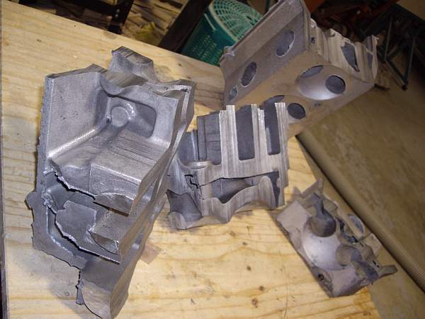 Broken engine block pieces on a wooden surface