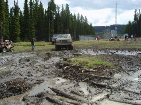 1995 Ford Bronco - A 1995 Ford Bronco navigates a muddy off-road course during an outdoor event.