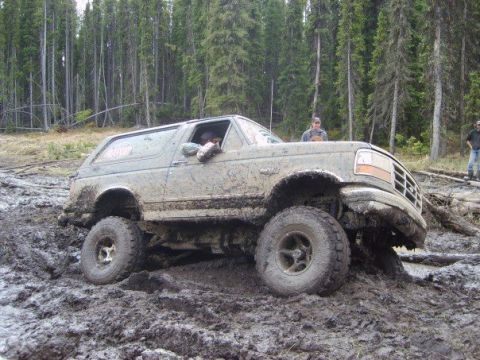 1995 Ford Bronco - Muddy 1995 Ford Bronco struggling through a difficult off-road trail.