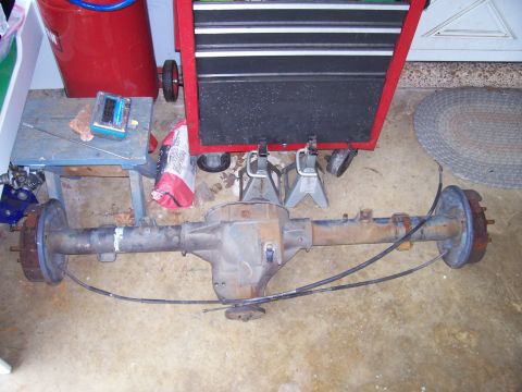 1989 Ford Bronco II - A rear axle assembly is shown on a garage floor, resting on jack stands.