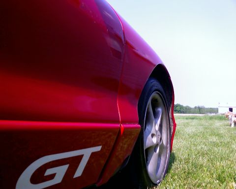 1993 Ford Probe - A close-up of a red car's side panel reveals a 'GT' decal and a portion of the wheel.