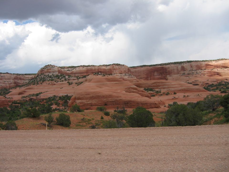 Desert landscape with red rock formations and a cloudy sky
