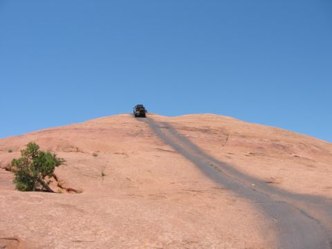 1997 Ford Ranger - A 4x4 vehicle ascends a challenging off-road trail on a large rock formation.