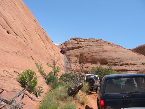 1997 Ford Ranger - Several off-road vehicles navigate a challenging sandy incline in a desert landscape.