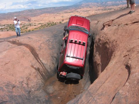 1997 Ford Ranger - Off-road vehicle navigating a challenging rocky terrain in a desert landscape.
