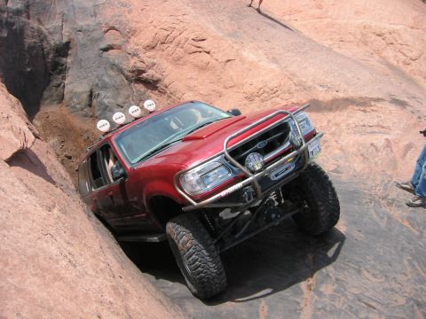 1997 Ford Ranger - This modified SUV is tackling a challenging off-road trail with steep rock formations.