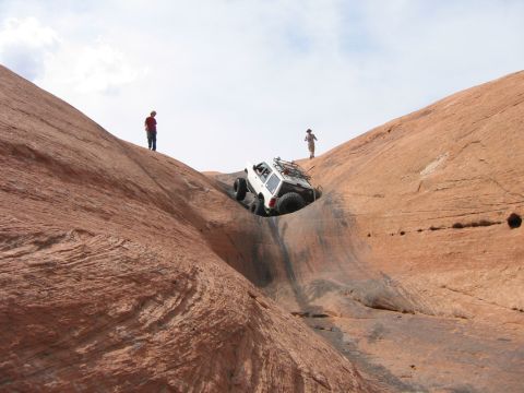 1997 Ford Ranger - A white 1997 Ford Ranger navigates a challenging off-road course on a steep, red rock incline.