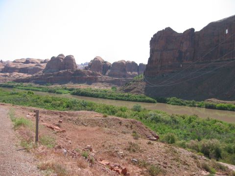 1997 Ford Ranger - A scenic view of a river winding through a canyon, with red rock cliffs and green vegetation under a clear sky.
