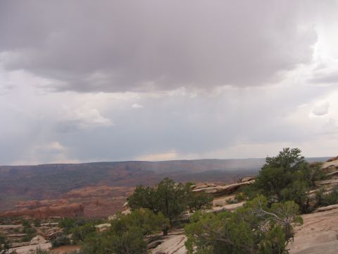 1997 Ford Ranger - Stormy skies over a desert canyon landscape with trees and rock formations.