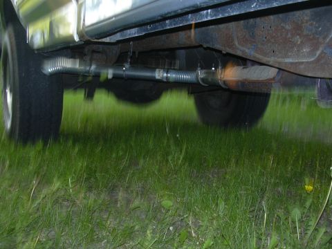 1992 Ford F-250 - The underside of a vehicle is shown, with focus on the exhaust system and rear tire.