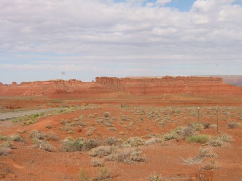 1997 Ford Ranger - A vast desert scene unfolds with layered red rock formations dominating the horizon under a partly cloudy sky.