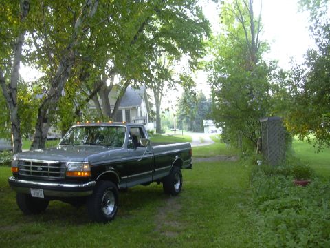 1992 Ford F-250 - This two-tone 1992 Ford F-250 pickup truck is parked on a lawn with trees and a house in the background.