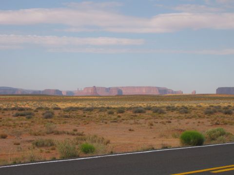 1997 Ford Ranger - A vast desert landscape with prominent mesas in the distance, captured from the side of a road.
